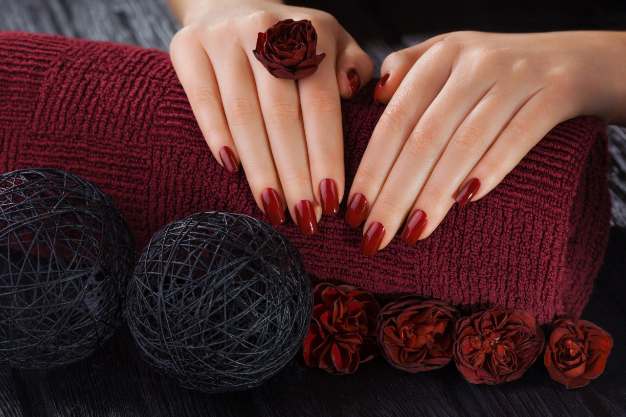 深紅のネイルを施した手